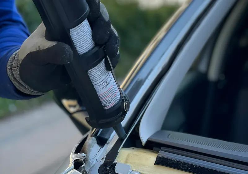 Technician installing new windshield on a vehicle